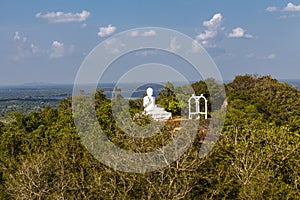 White Buddha statue opn top of a hill in Mihintale, Sri Lanka