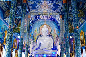 White buddha statue in Wat Rong Sua Ten temple with blue sky background, Chiang Rai Province, Thailand photo