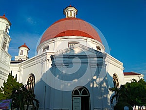 A white building with an orange dome left behind by the invaders and a dove on top of it