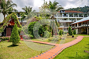 White building of a small hotel surrounded by a beautiful tropical park