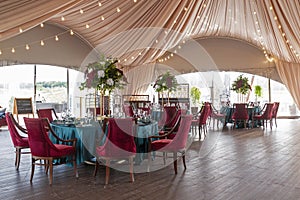 White and Burgundy floral arrangements in the summer tent