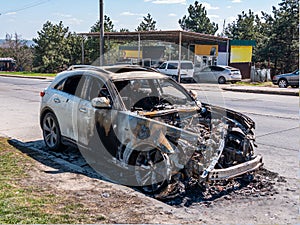 White Burned car at the edge of the road