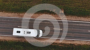 White bus drives along asphalt road with marking aerial