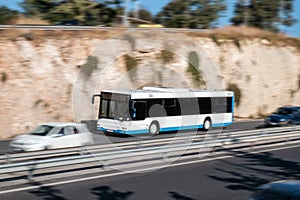 White bus moving fast along the street on a motion blurred background. Bus driving on freeway,