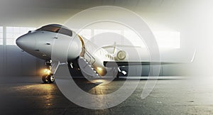 White business private jet airplane parked at aircraft hangar. Luxury tourism and business travel transportation concept