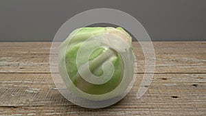 White cabbage rolls on a wooden surface on a gray background.