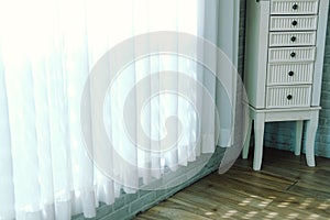 White cabinet with drawer & see through sheer window curtain at home