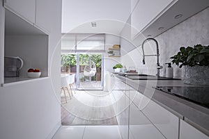 White cabinets in bright modern kitchen interior of house with terrace. Real photo photo