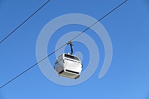 A white cable-car with a blue background.