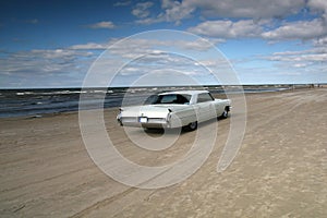 White cadillac on a beach