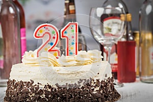 White cake with chooclate decorations and 21 candles. Alcoholi