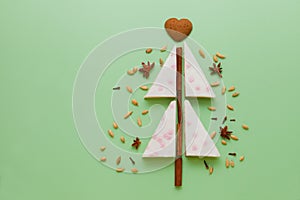 white cake christmas tree shaped with Gingerbread, anise stars, cinnamon pie flat lay on green table