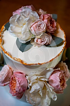 white cake decorated with live flowers. Traditional wedding cake.