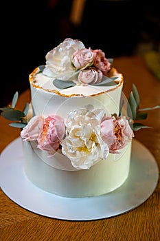 white cake decorated with live flowers. Traditional wedding cake.