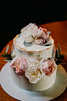 white cake decorated with live flowers. Traditional wedding cake.