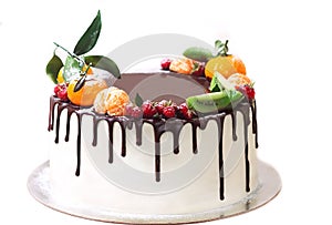 White cake drenched in chocolate and decorated with berries on an isolated white background.