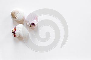 A white cake lies on a white plate on a light background. Light macaroons. Delicious pastries