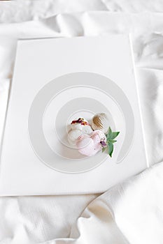 A white cake lies on a white plate on a light background. Light macaroons. Delicious pastries