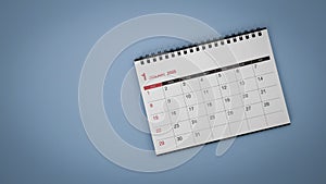 White calendar laying on blue background planning concept.