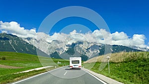 A white camper 7 caravan on a lonely road into the Swiss alps