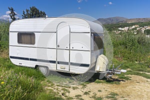 White camping trailer parked on countryside.