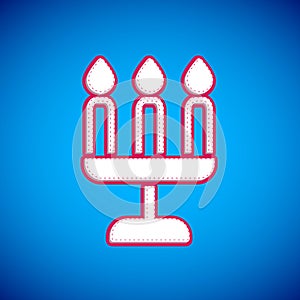 White Candelabrum with three candlesticks icon isolated on blue background. Vector