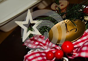 White candle and Christmas decoration over snow and wooden background, elegant shot with festive mood