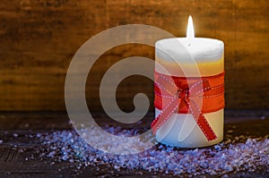 White candle with red bow for Advent or Christmas.