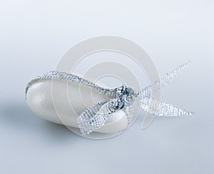 White candy-coated almond tied with a silver ribbon