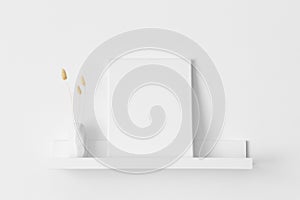 White canvas mockup with a lagurus decoration on the wall shelf