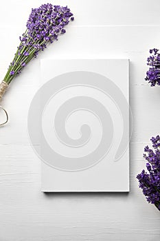 White canvas mockup and lavender flowers bouquet on white wooden table background, flat lay