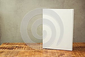 White canvas on wooden table over rustic background. Mock up template