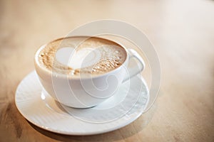 White cappuccino cup on light brown wood background