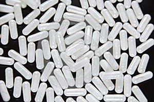 White capsules on a black