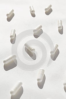 White capsules closeup. Healthcare concept. Morning routine theme. Supplements and vitamins