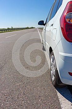 White car on beautiful empty highway. Transport concept. Speed and motion background. Adventure time concept.