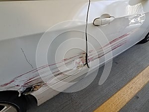 White car with big scratch with red paint