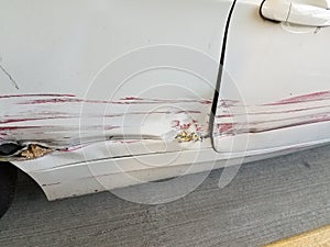 White car with big scratch with red paint