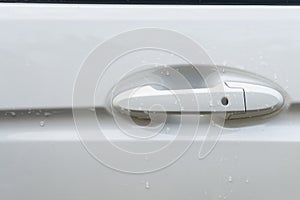White car door handle with water drop abstract background.