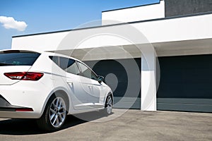 White car in front of modern house with garage door