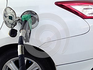 White car fuel filler at fuel station. Fuel dispenser at gas station.