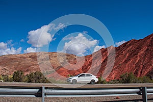 White car parked against the backdrop of a majestic mountain range, Fiambala , Catamarca, Argentina photo