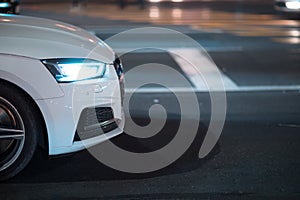 White car in road at night