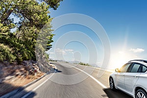 White car rushing along a high-speed highway.