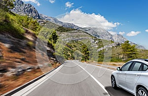 White car rushing along a high-speed highway.