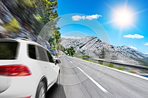 White car rushing along a high-speed highway.