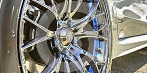White car with silver tire rim and blue bolts