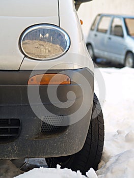 White car in snow with wheels turned to the left