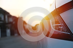 White car tail light with evening sun