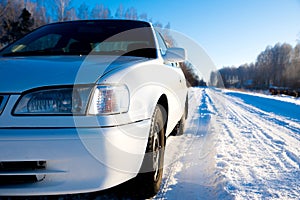 White car on winter snowy country road